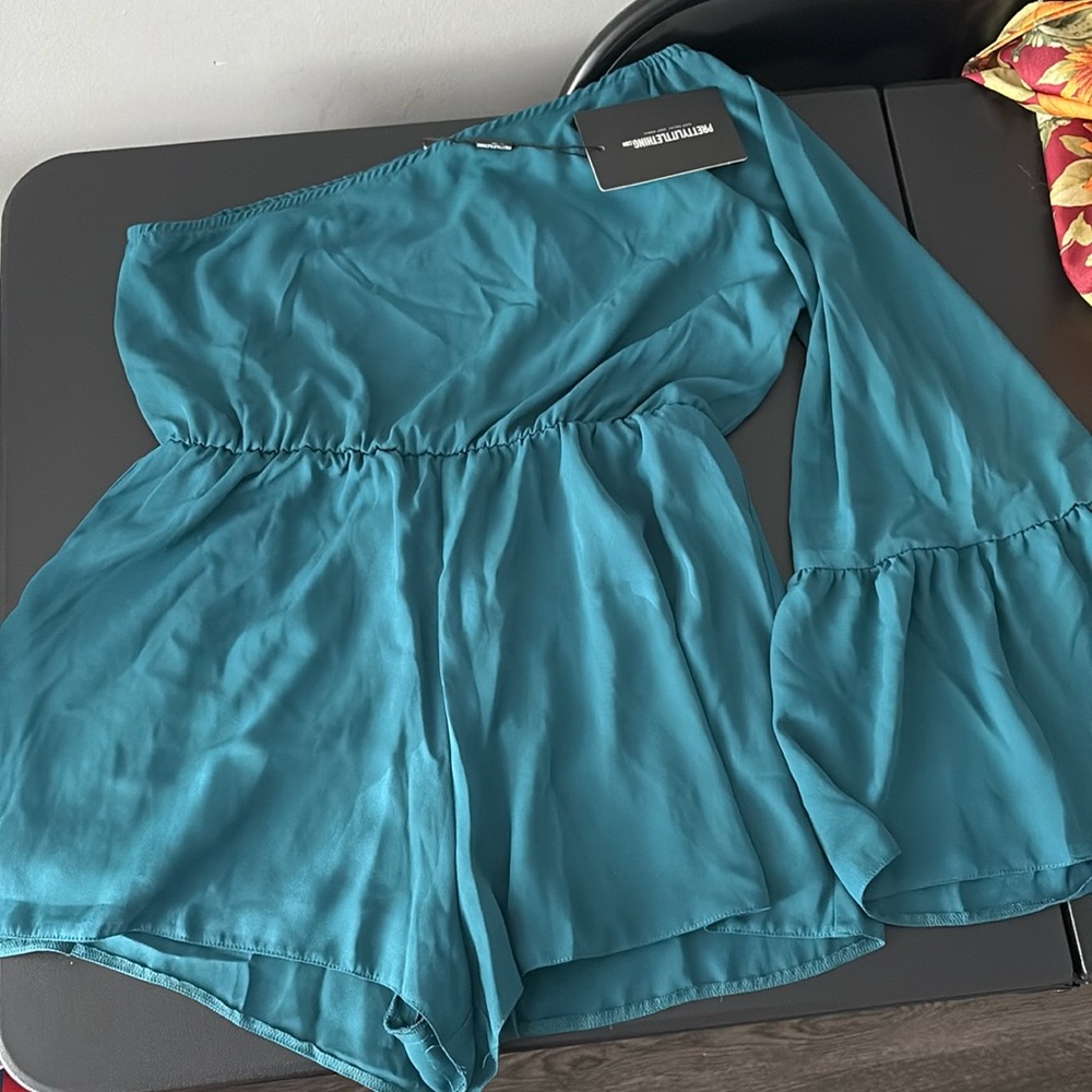 Emerald green romper. Right side sleeveless, left side long/flare sleeve.